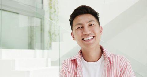 Cheerful Young Asian Man Smiling Indoors in Modern Home - Download Free Stock Images Pikwizard.com