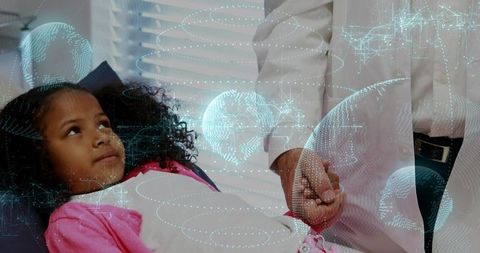 Pediatrician reaching and holding child's hand during comforting exam with digital health hologram