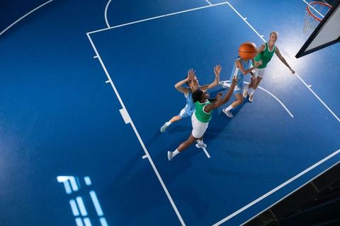 Dynamic Female Basketball Players Jumping on Court During Game