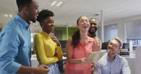 Diverse Colleagues Laughing Around Tablet in Modern Office - Download Free Stock Images Pikwizard.com