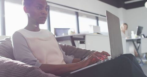 Businesswoman Using Laptop in Modern Office Lounge Area