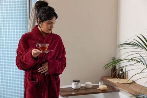 Woman enjoys tea in bathroom for relaxation and wellness