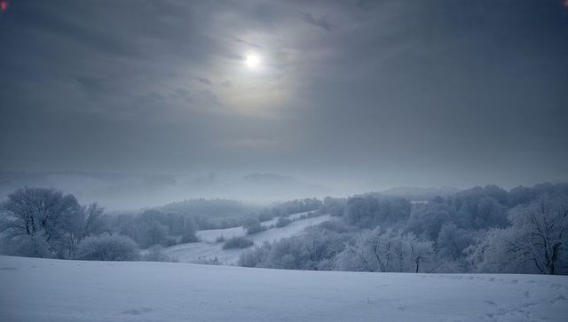Moonlit Frost-Covered Valley with Rolling Snow Hills and Misty Winter Morning
