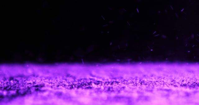 Close-up of a purple surface illuminated by ultraviolet (UV) light, capturing floating particles and texture details. Suitable for use in futuristic designs, backgrounds, scientific visuals, technology presentations, or creative projects needing a mysterious and abstract look.