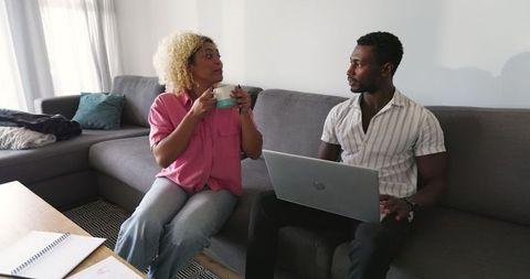Diverse Professionals Brainstorming Together on Sofa with Laptop