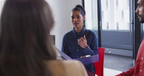 Confident businesswoman leading office discussion with colleagues