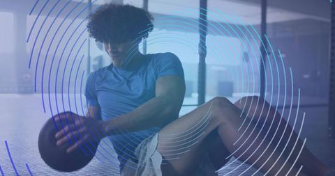 Athletic Male Doing Russian Twists with Medicine Ball in Gym