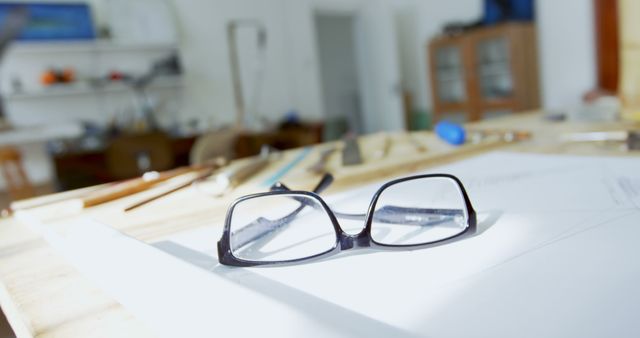 Black glasses on architect's desk with drafting tools in the background - Download Free Stock Images Pikwizard.com