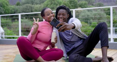 African American Couple Taking Rooftop Yoga Selfie in Activewear Smiling and Relaxing