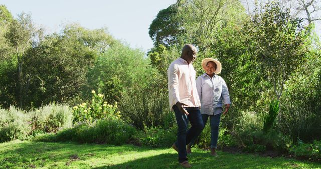 Happy african american senior couple walking outdoors. retirement lifestyle, spending time at home and garden.