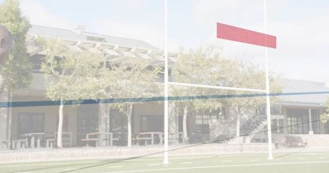 Framing white football goalposts featuring red banner on campus end zone with seating