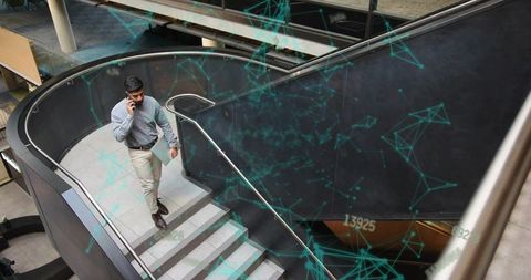 Businessman Engaged with Technology While Ascending Office Staircase