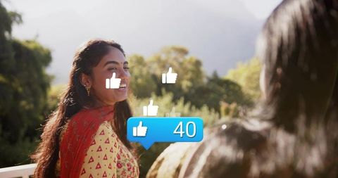 Indian woman smiling on sunlit balcony wearing kurta and red dupatta with 40 likes outdoors