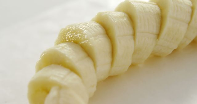 Sliced banana pieces are arranged in a row on a white background, with copy space. Bananas are a nutritious fruit, rich in potassium and dietary fiber, often used in healthy eating.