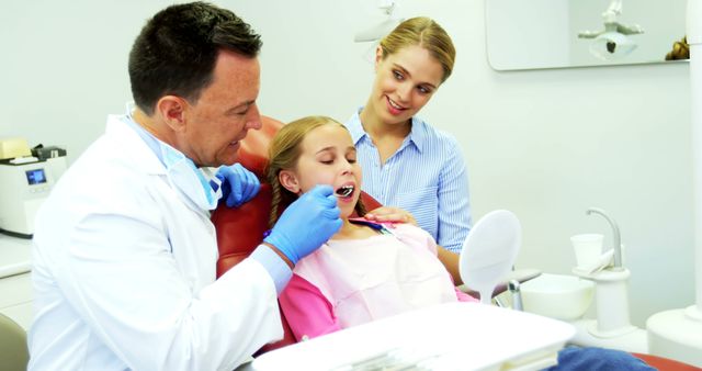 Dentist Examining Girl's Teeth as Mother Observes in Dental Clinic - Download Free Stock Images Pikwizard.com