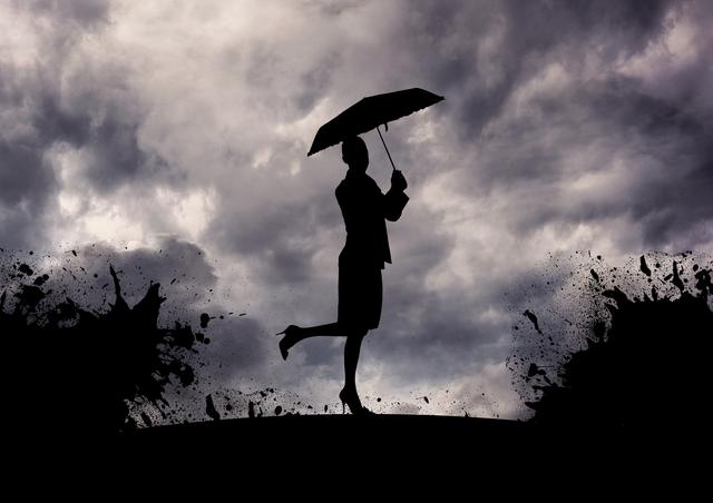 Silhouette of woman standing with umbrella in stormy weather