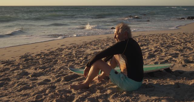 Senior Man Relaxing on Beach at Sunset with Surfboard - Download Free Stock Images Pikwizard.com