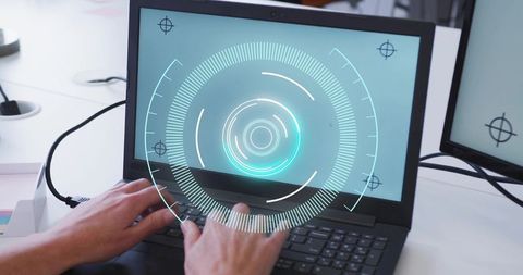 Typing on laptop showing futuristic hud interface over screen in modern office workspace