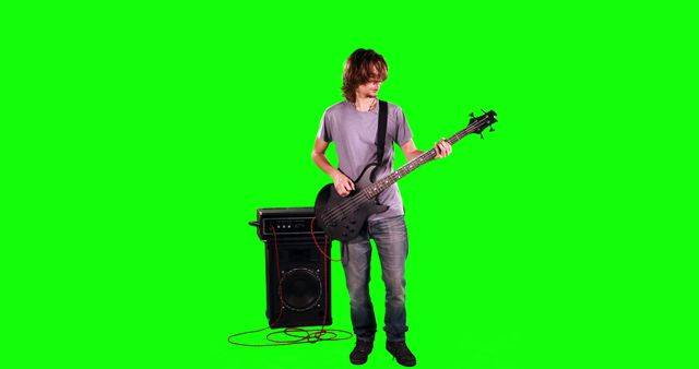 Young Man Playing Guitar Standing In Front Of Amplifier On Green Screen - Download Free Stock Images Pikwizard.com