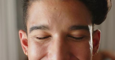 Relaxed african american man resting with eyes closed showing scar and gold hoop earrings
