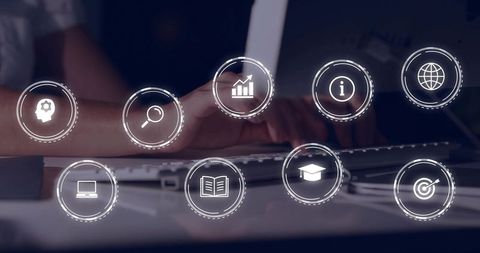 Mid-adult woman typing at office desk with holographic UI icons for productivity analytics