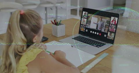 Schoolgirl attending virtual classroom at kitchen table studying online with laptop