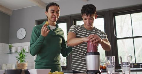 Diverse Male Couple Making Fresh Smoothie in Modern Kitchen