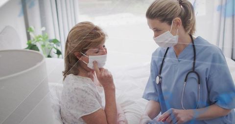 Nurse Providing Compassionate Care to Senior Woman Wearing Surgical Mask in Bright Bedroom