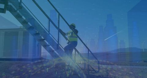 Engineer climbing stairs at wind farm for maintenance