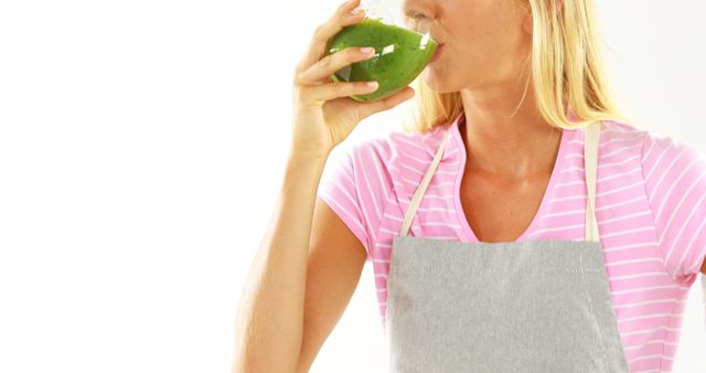 Woman Drinking Healthy Green Smoothie in Gray Apron - Download Free Stock Images Pikwizard.com