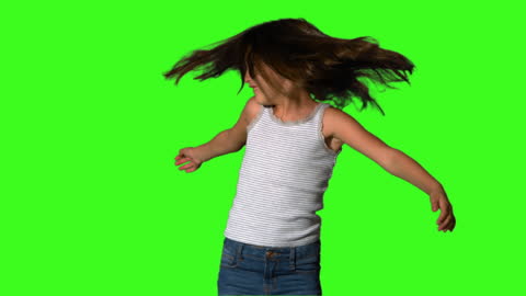 Joyful Girl Twirling Against Green Screen in Motion
