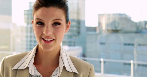 Confident Businesswoman Smiling in sunlit Office with Unfocused Cityscape - Download Free Stock Images Pikwizard.com