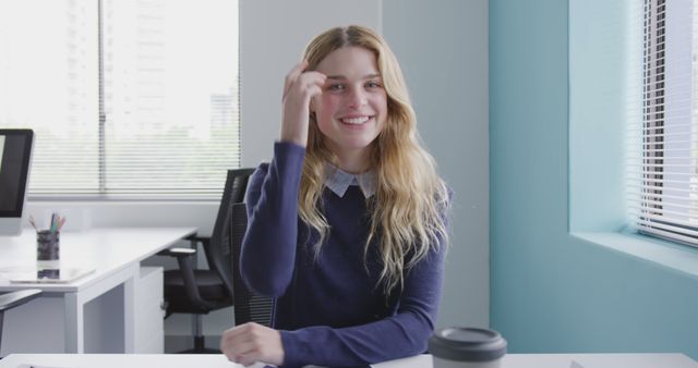 Smiling Young Woman Sitting at Desk in Modern Office - Download Free Stock Images Pikwizard.com