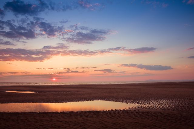 Serene Sunset over Calm Sea and Sandy Beach with Reflected Sky - Download Free Stock Photos Pikwizard.com