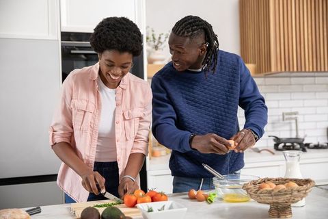 Couple Sharing Joyful Cooking Experience in Modern Kitchen