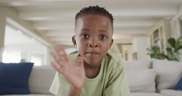 Smiling African American Boy Waving at Camera Indoors - Download Free Stock Images Pikwizard.com