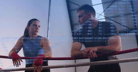 Female boxer receiving coaching in industrial gym with data overlay tracking performance and focus