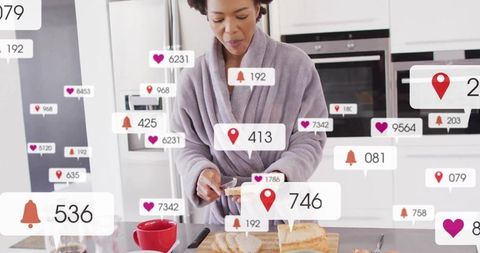 Mid-adult african american woman preparing breakfast in kitchen with social media alerts