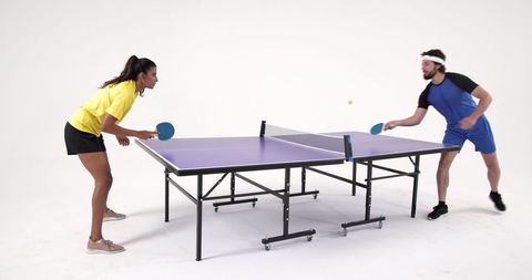 Competitive Friends Playing Table Tennis in Minimalist Studio