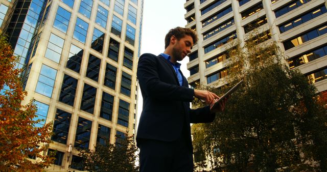 Businessman Using Tablet in Urban Setting with Skyscrapers - Download Free Stock Images Pikwizard.com