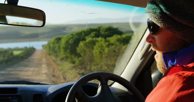 Man Driving Through Scenic Countryside in Winter Gear - Download Free Stock Images Pikwizard.com