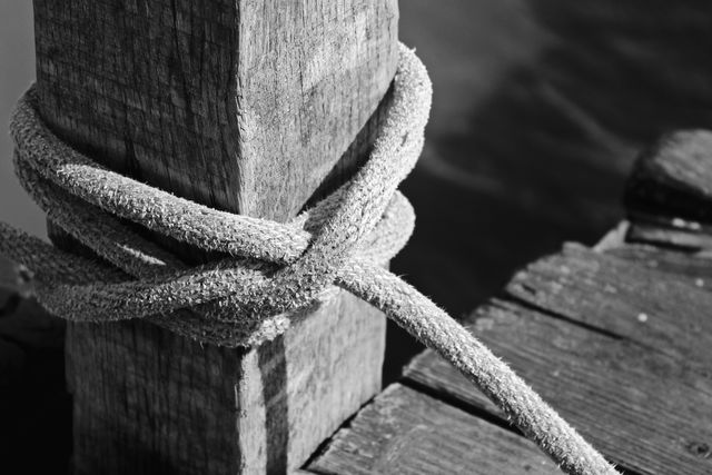 Close-Up of Worn Rope Tied Around Weathered Wooden Post - Download Free Stock Photos Pikwizard.com