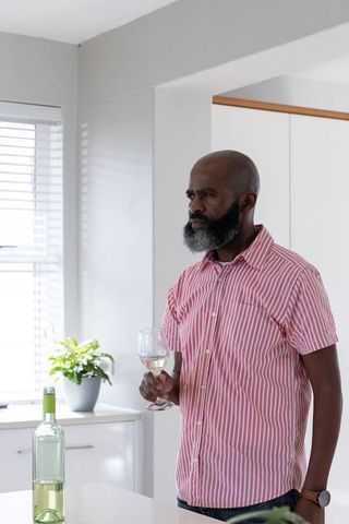 African American Man Enjoying Wine in Modern Kitchen