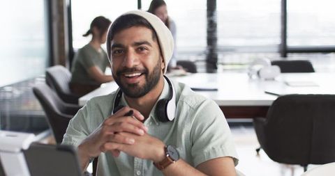 Smiling young professional with tablet in modern workspace