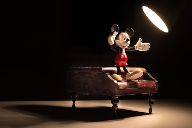 Mickey Mouse Two-Fingers up on Vintage Piano Finely Highlighted by Spotlight - Download Free Stock Images Pikwizard.com