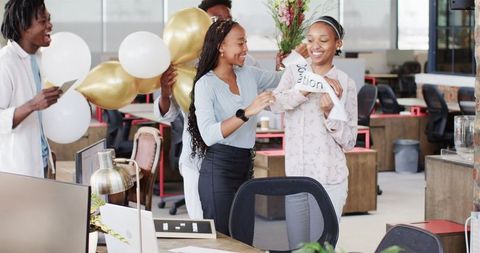 Diverse Team Celebrating Success with Gifts in Modern Office