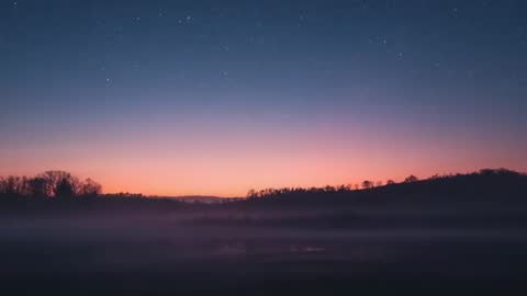 Stars Fading Over Misty Valley While Dawn Brightens Hills and Pasture