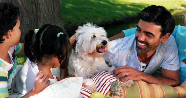 Happy family enjoying together with their pet dog in park 