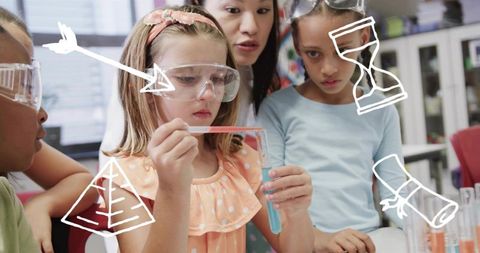 Young students conducting hands-on science experiment with pipette, test tube and goggles