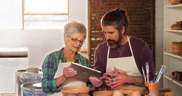 Elderly Woman and Man Using Tablet in Pottery Studio - Download Free Stock Images Pikwizard.com